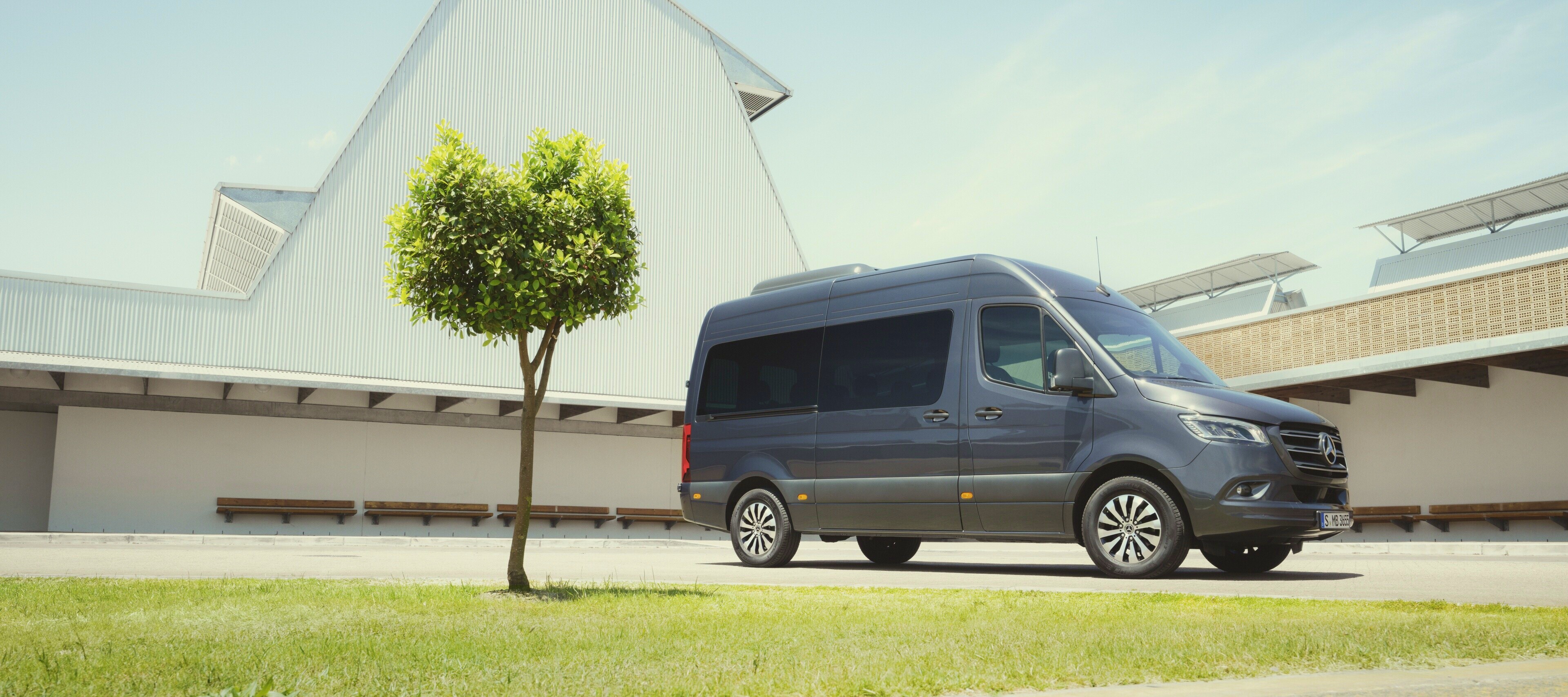 Sprinter Tourer | Mercedes-Benz Transporter. Der Sprinter Tourer von Mercedes-Benz neben einer Grünfläche.
