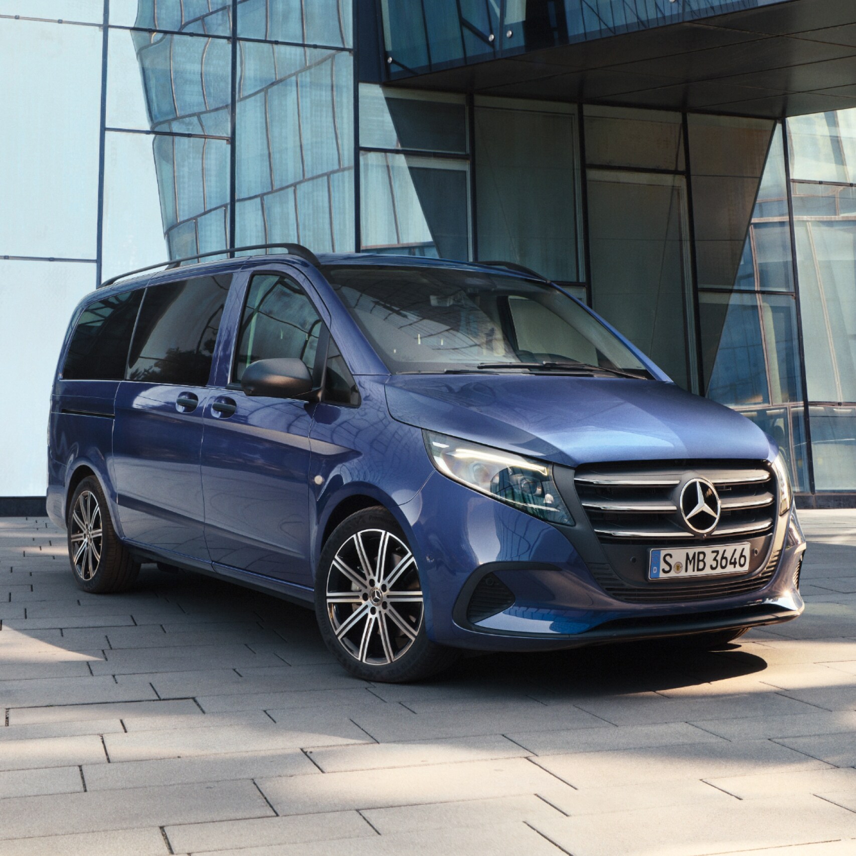 Der Mercedes-Benz Vito Tourer vor einem Bürogebäude.