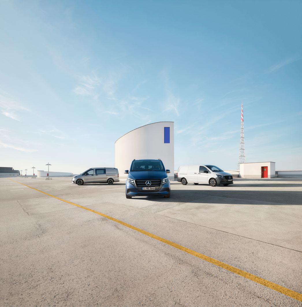 Vito | Mercedes-Benz Transporter Drei Mercedes-Benz Vitos stehen auf einem großen Parkplatz vor einem modernen weißen Gebäude.