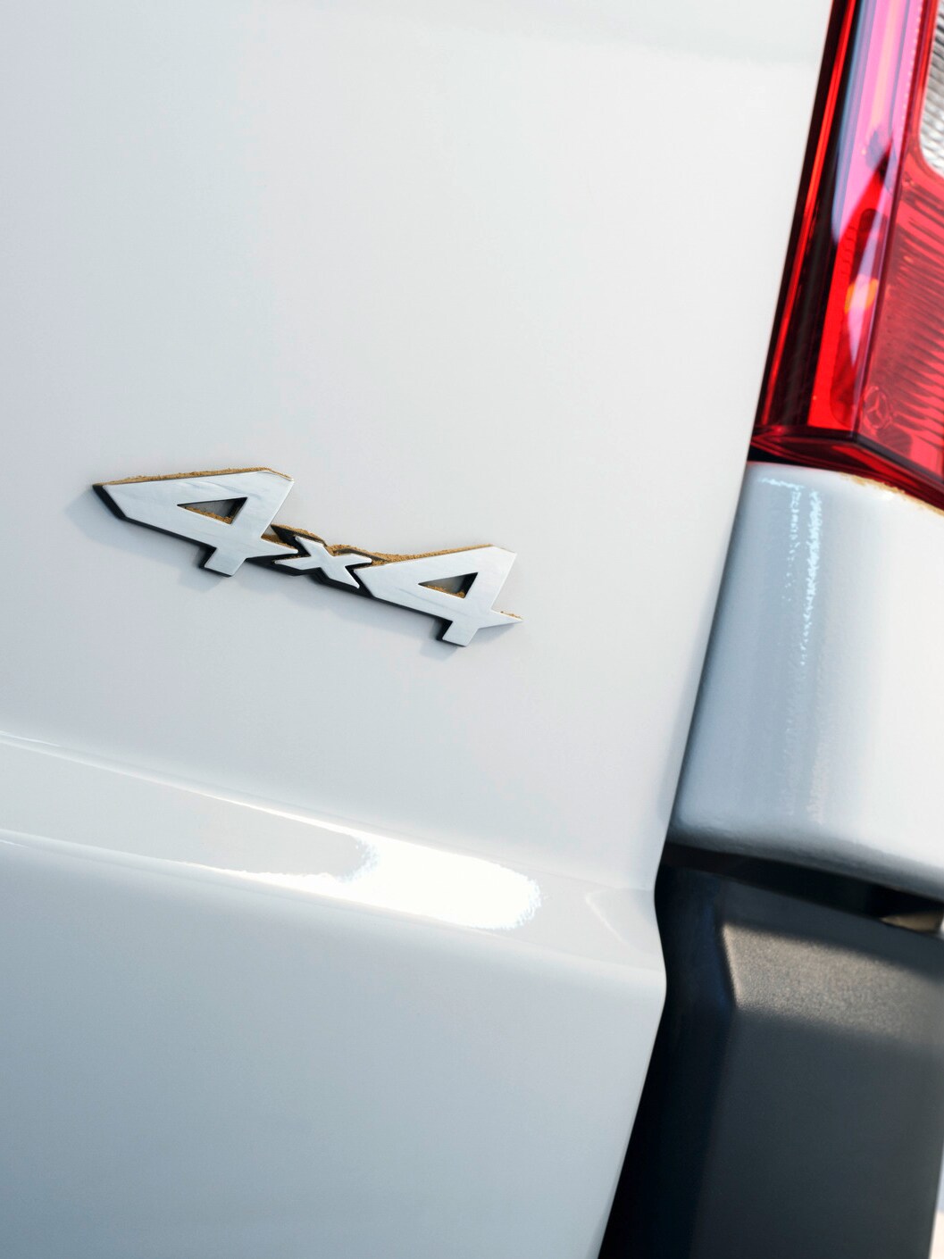 Das Heck eines silbernen Vito Kastenwagens mit 4x4-Plakette und roten Leuchten.