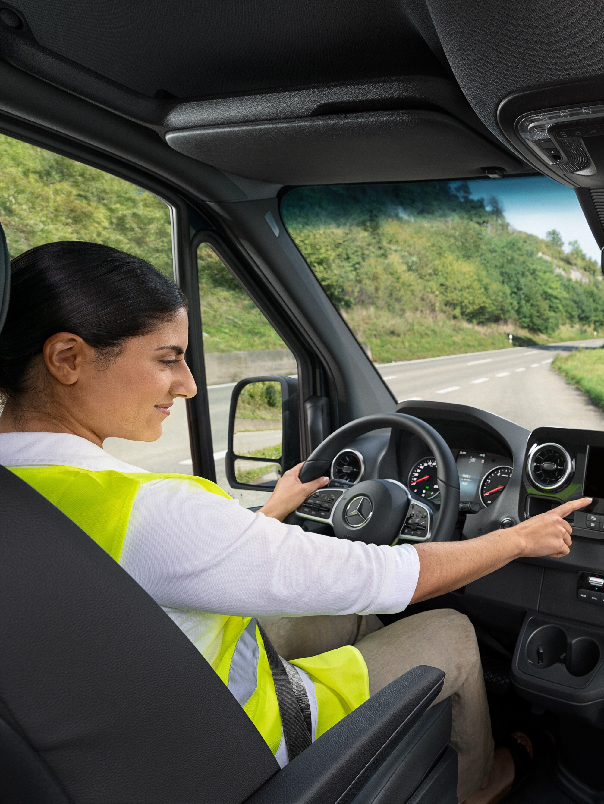 Fahrerin im Mercedes-Benz Sprinter ruft bei Problemen die Mercedes-Benz Service24h-Hotline über das Bordmenü an.