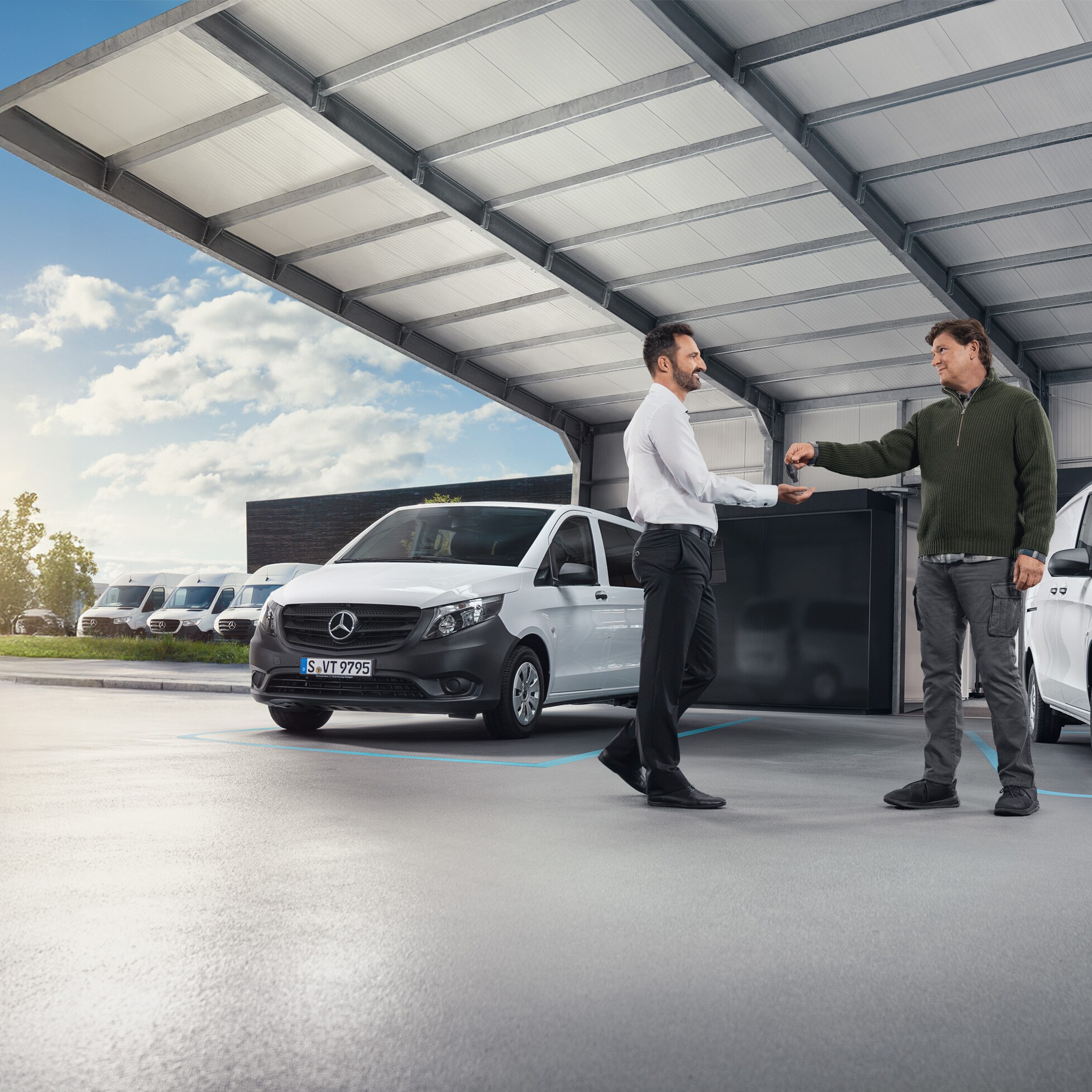 Zwei Männer besprechen sich vor Mercedes-Benz Vans in einer Halle – individuelle Betreuung und Gewerbeberatung für Geschäftskunden.