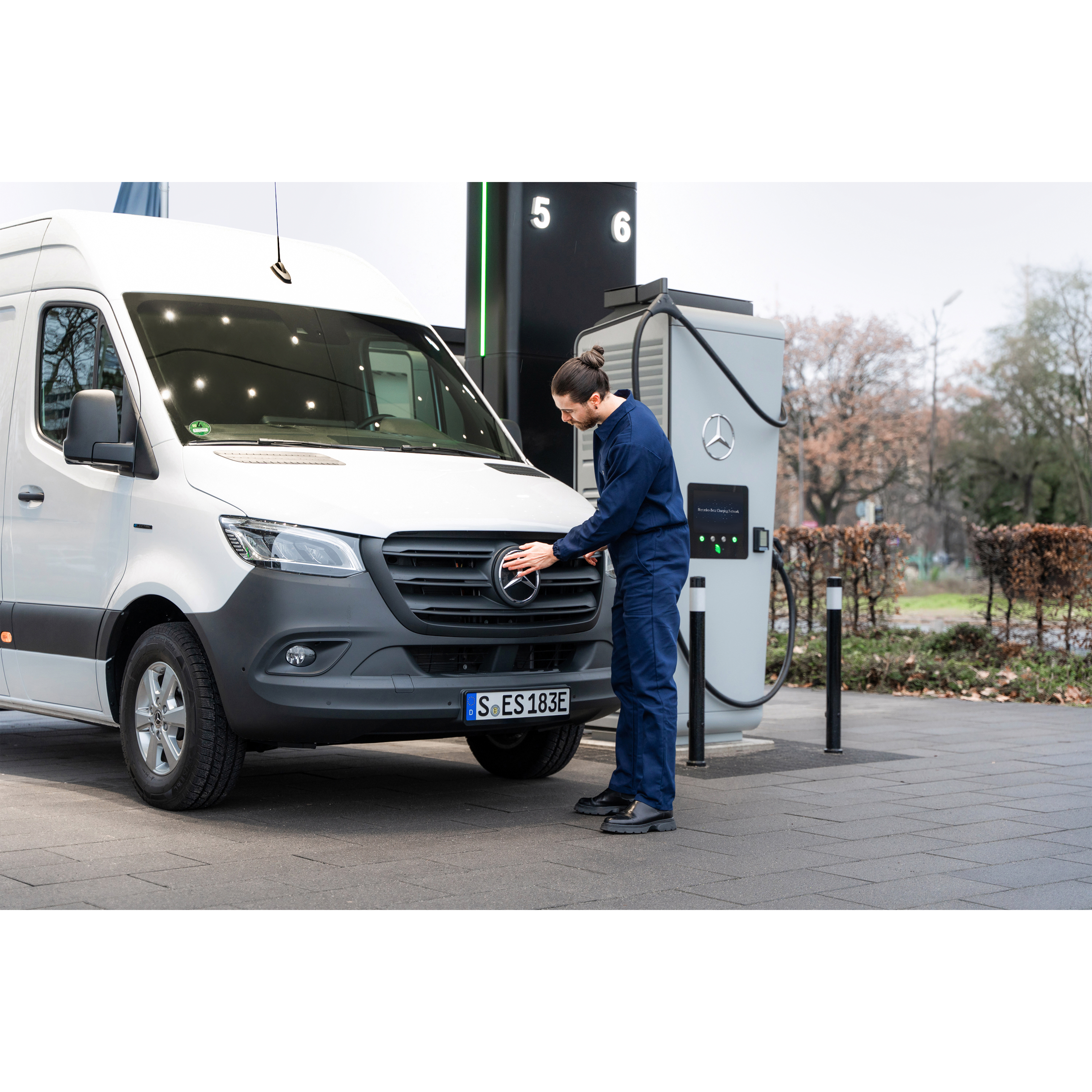 Ladelösungen | Mercedes-Benz Transporter. Ein Mercedes-Benz Transporter steht an einer Ladesäule und wird von einem Mann angeschlossen.