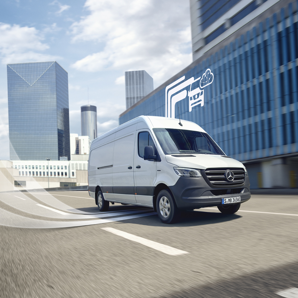 Weißer Sprinter Kastenwagen parkend vor einem Bürogebäude.