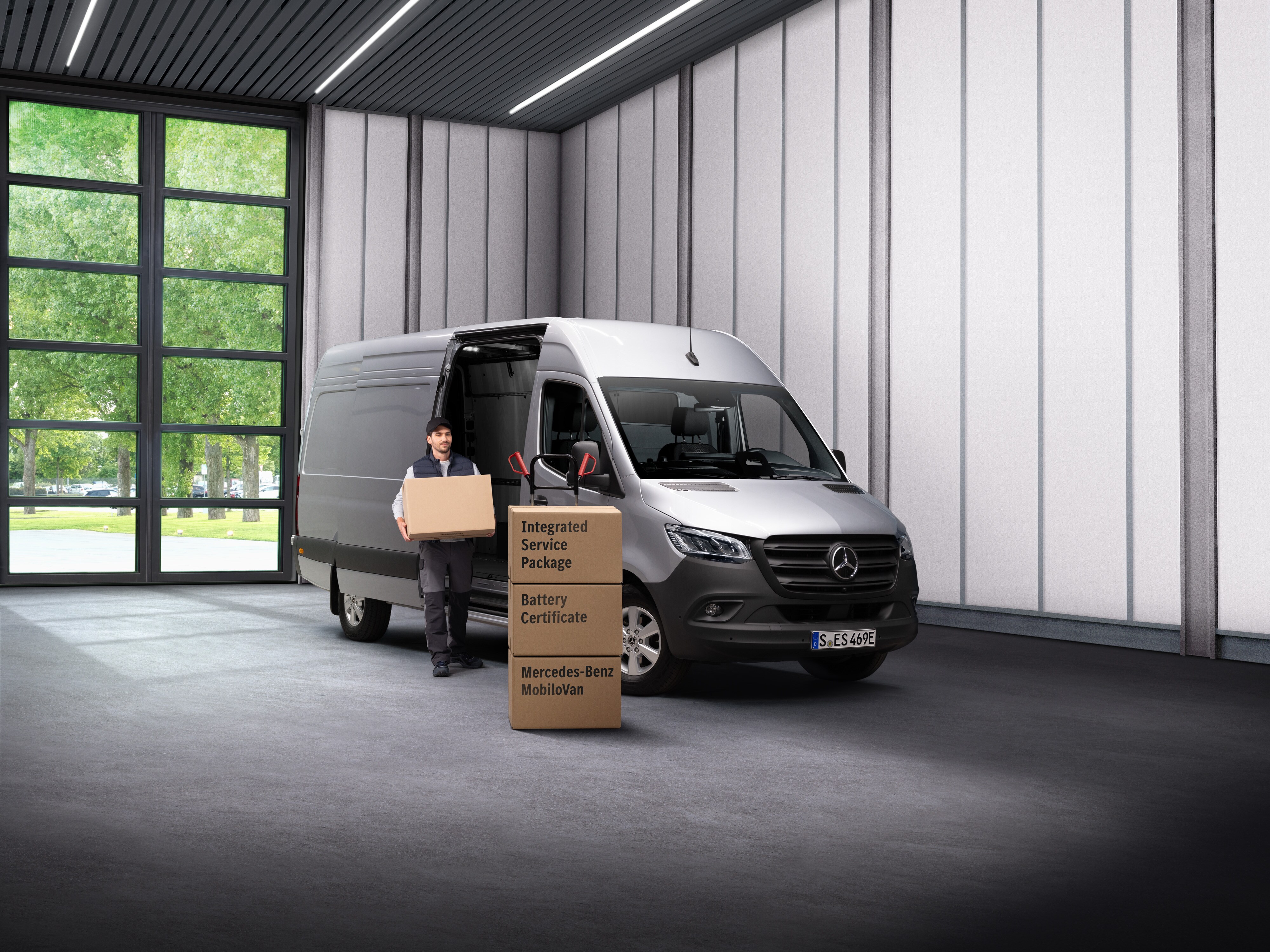 Ein Mercedes-Benz Elektroservice-Mitarbeiter trägt Kisten aus einem Transportfahrzeug