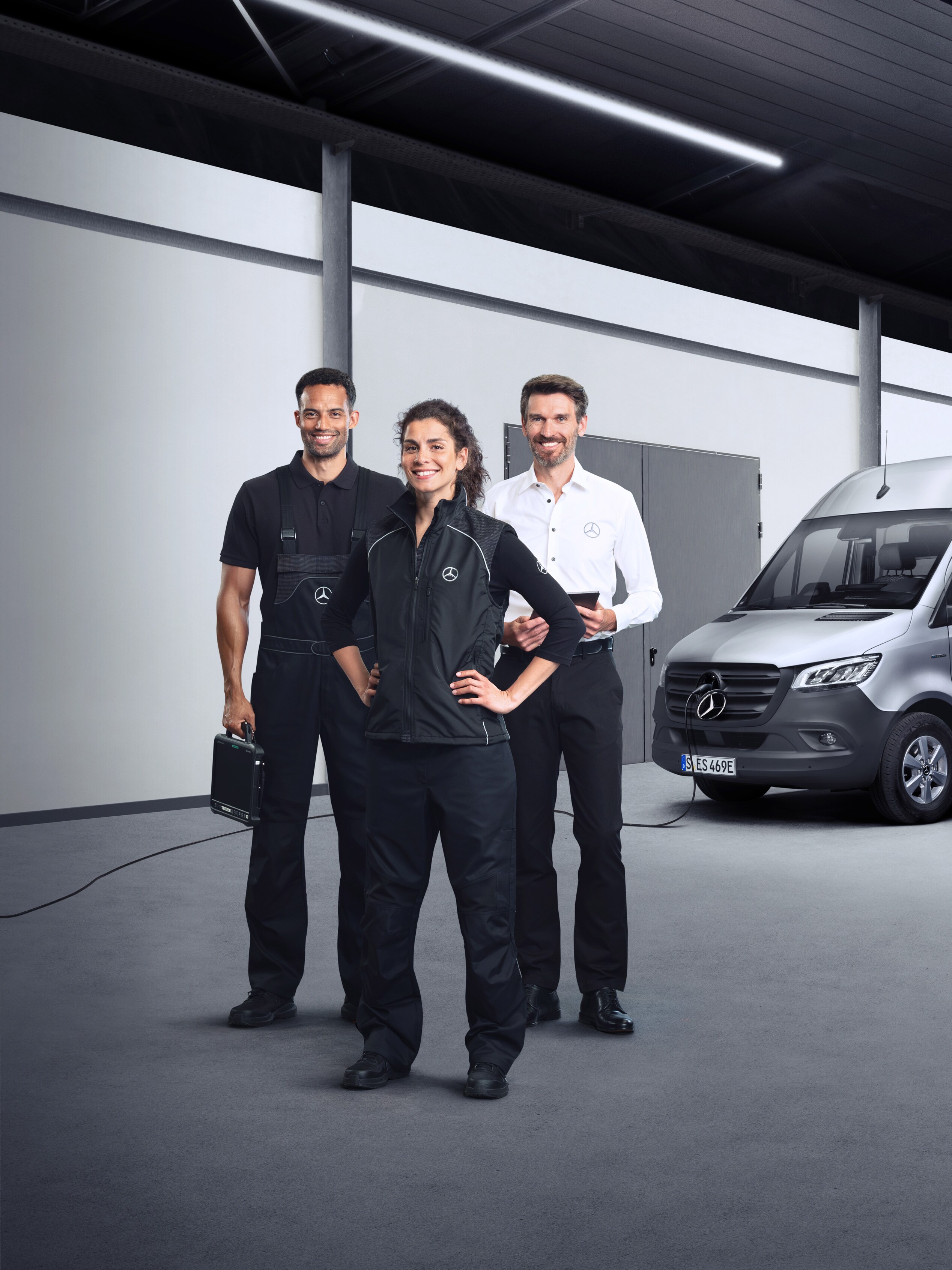 Drei Mitarbeitende stehen vor einem Mercedes-Benz eVan – kompetenter Nutzfahrzeuge-Service für Ihren Fuhrpark.