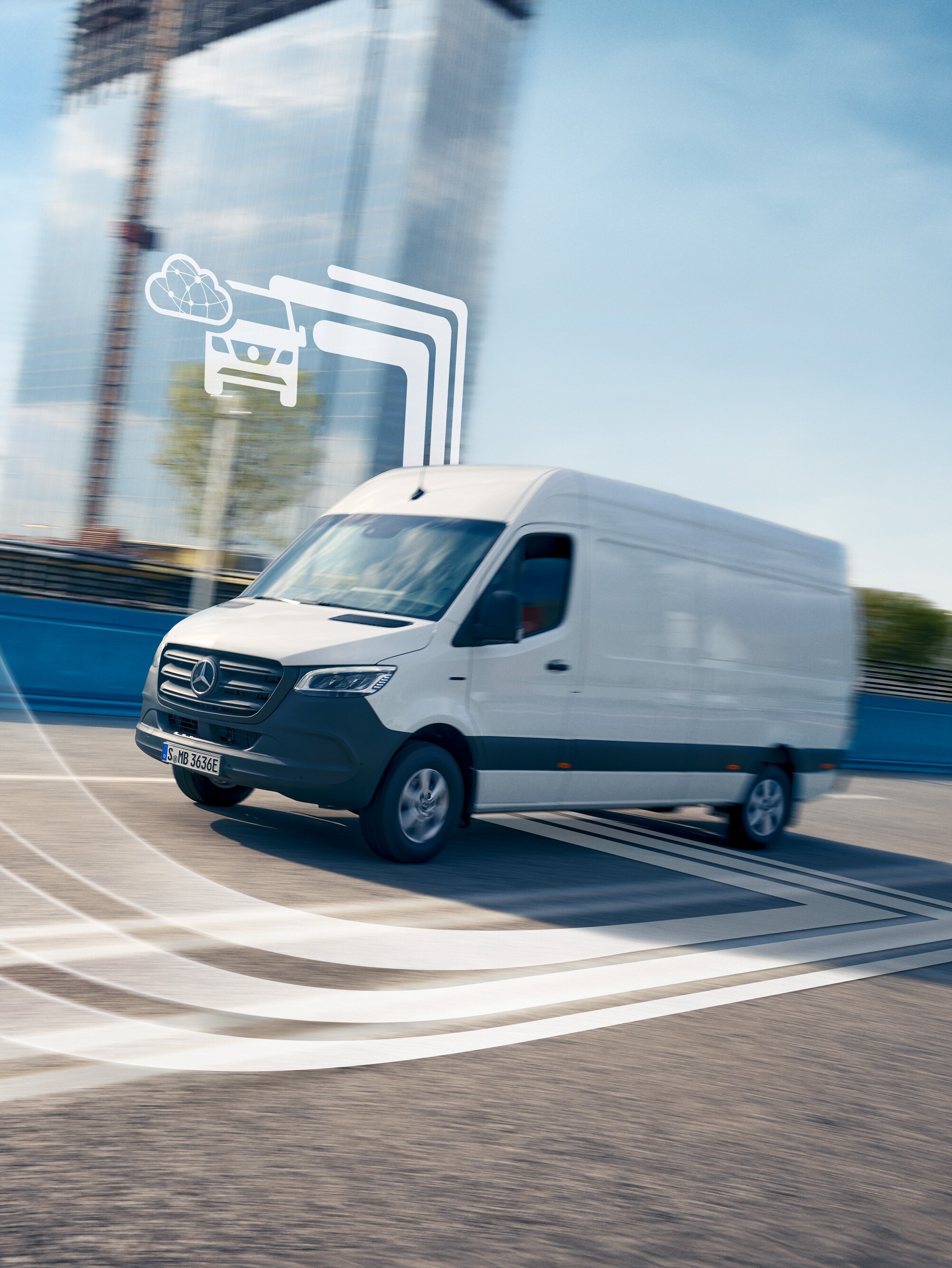 Ein digital vernetzter weißer Mercedes-Benz Sprinter Transporter auf einer sonnenbeschienenen Straße.