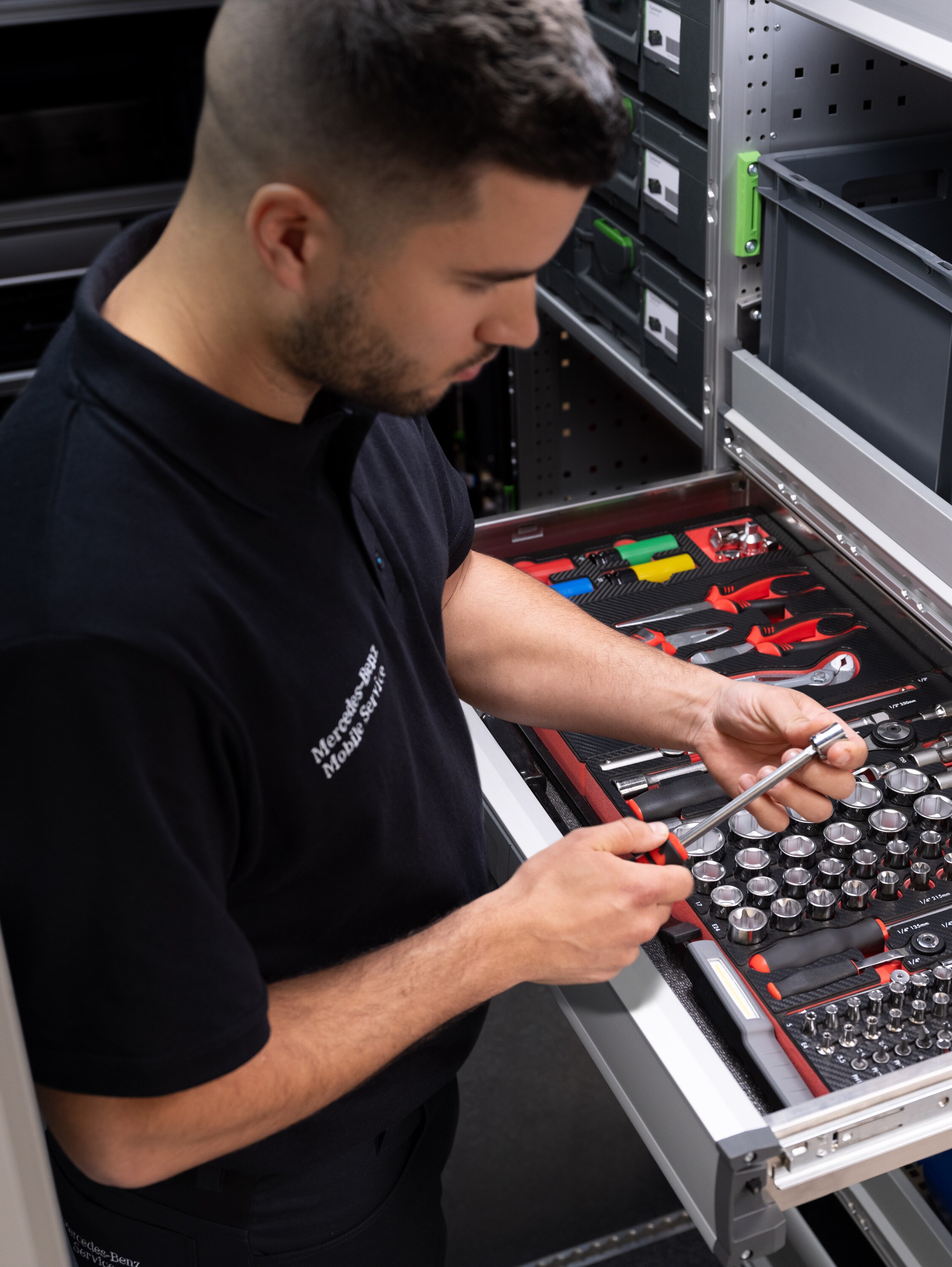 Ein Techniker wählt Werkzeug aus dem Van – schnelle und flexible Hilfe durch mobilem Werkstattservice.