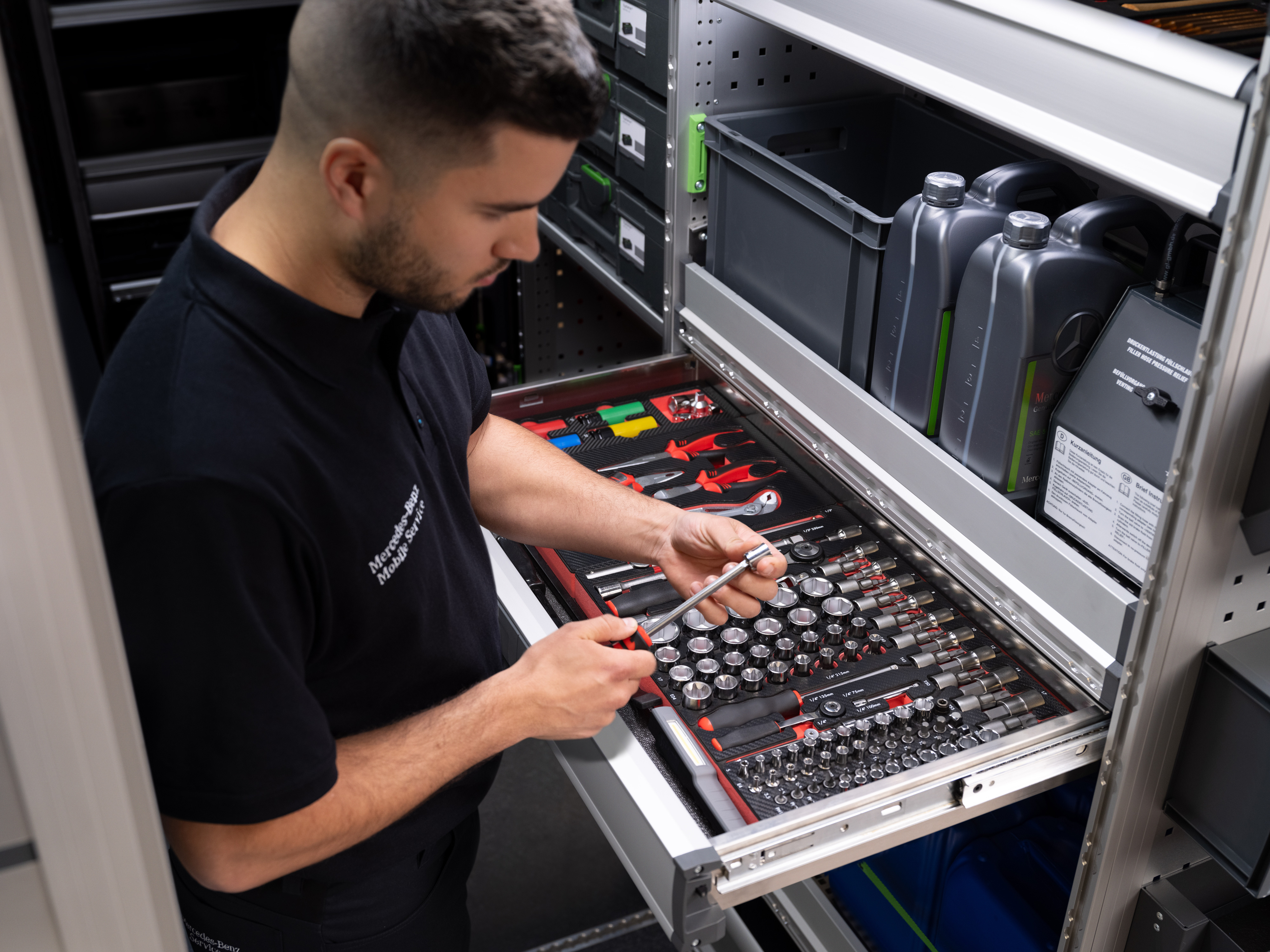 Mercedes-Benz | Mobile Service | Elektronik Ein Techniker wählt einen Gegenstand aus einer Schublade voller Werkzeuge aus.