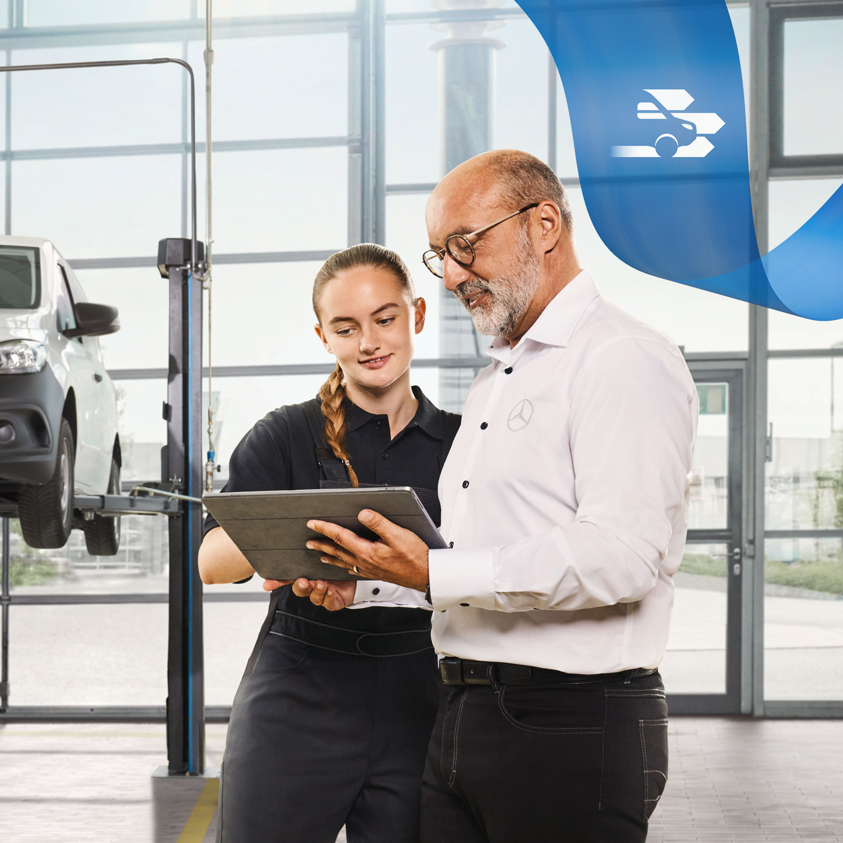 Fahrzeugwartung | Mercedes-Benz Transporter. Zwei Mitarbeitende besprechen den Nutzfahrzeuge-Service an einem aufgebockten Mercedes-Benz Transporter in der Werkstatt.
