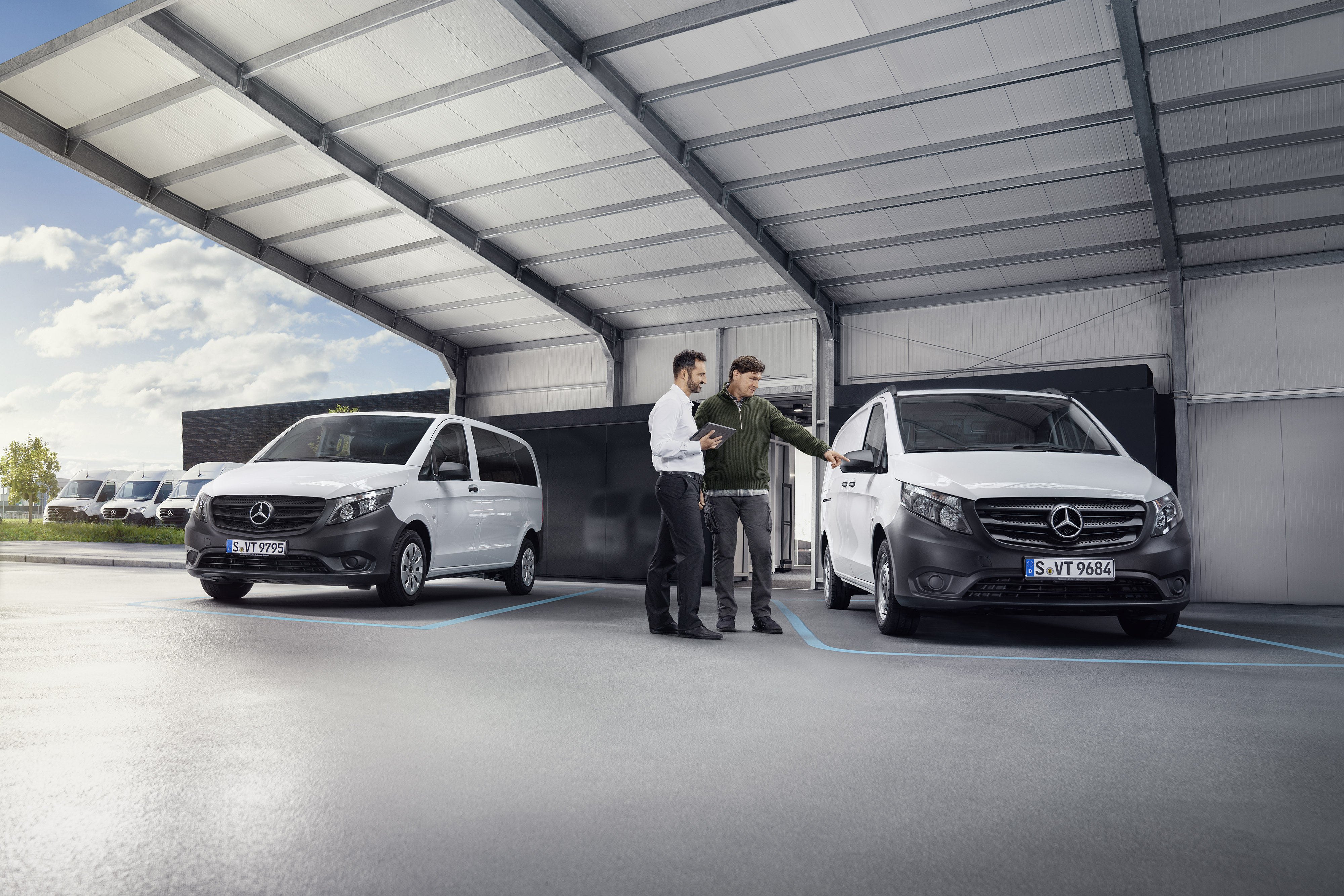 Rückruf | Mercedes-Benz Transporter. Mercedes-Benz Kundenbetreuer mit Kunde im Betrieb eines Servicepartners vor einem Transporter.