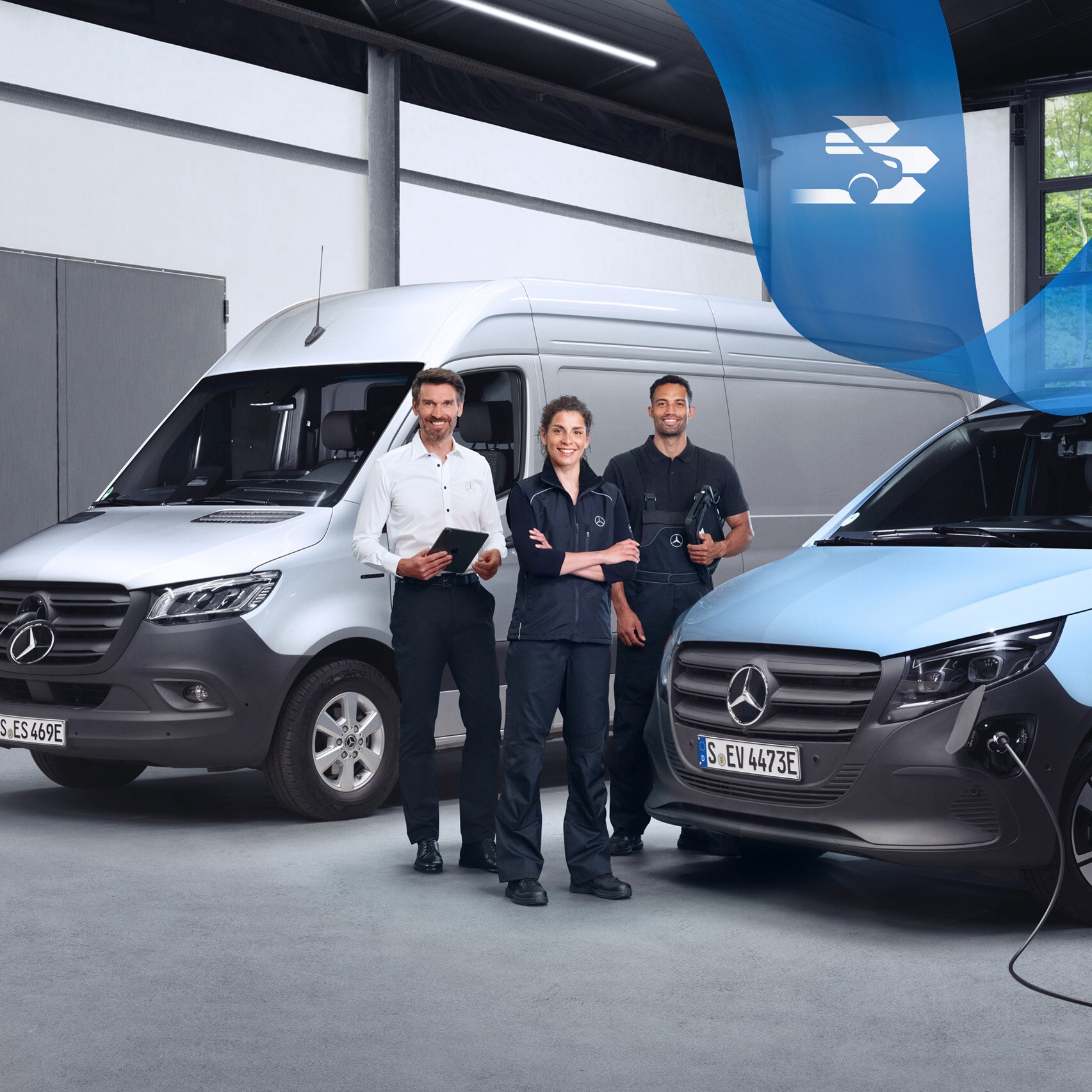 Drei Personen stehen zwischen zwei Transportern von Mercedes-Benz mit Elektroantrieb, die geladen werden.
