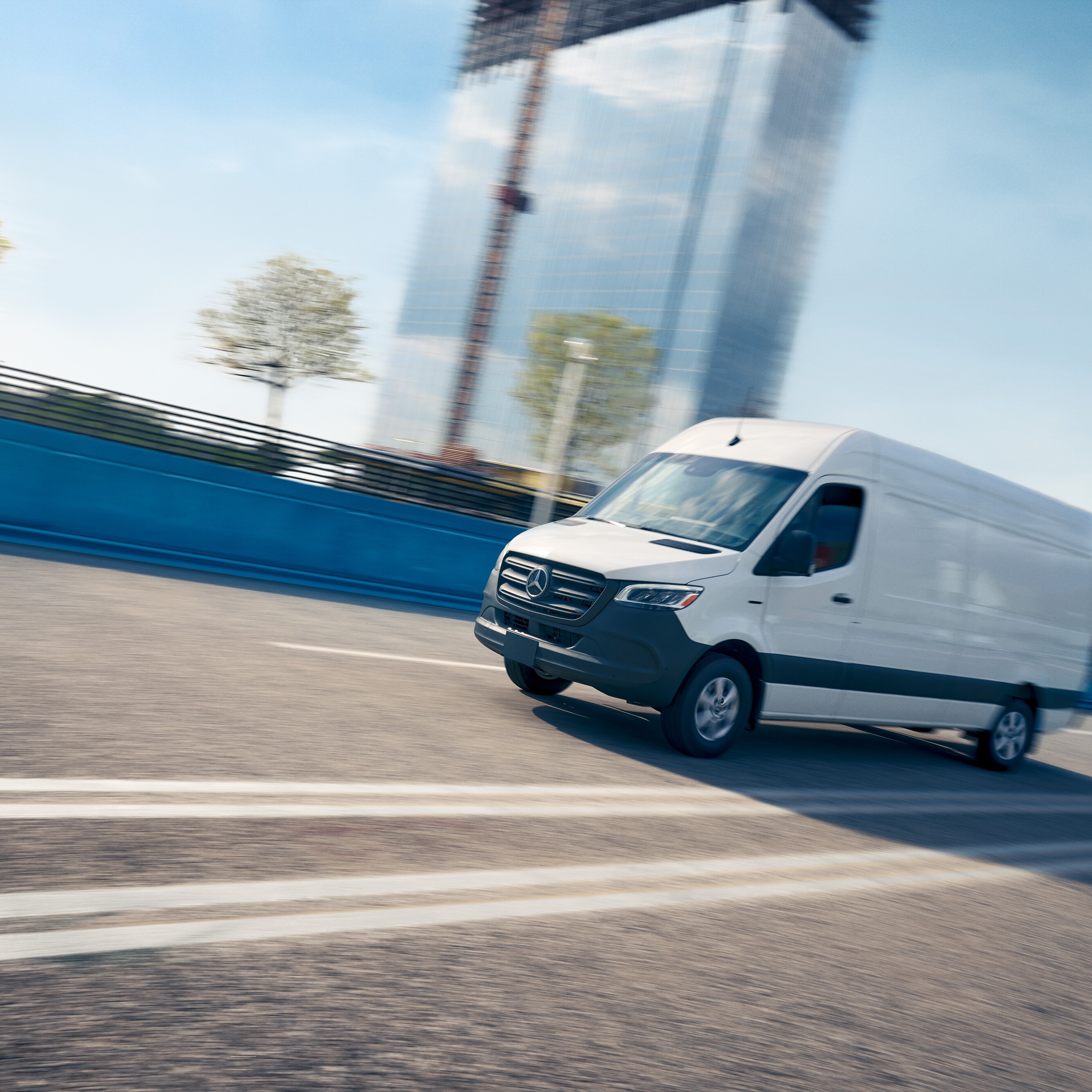 Ein weißer Lieferwagen fährt auf einer Straße und wirbt für die Mercedes-Benz Service-App mit Online-Terminbuchung.