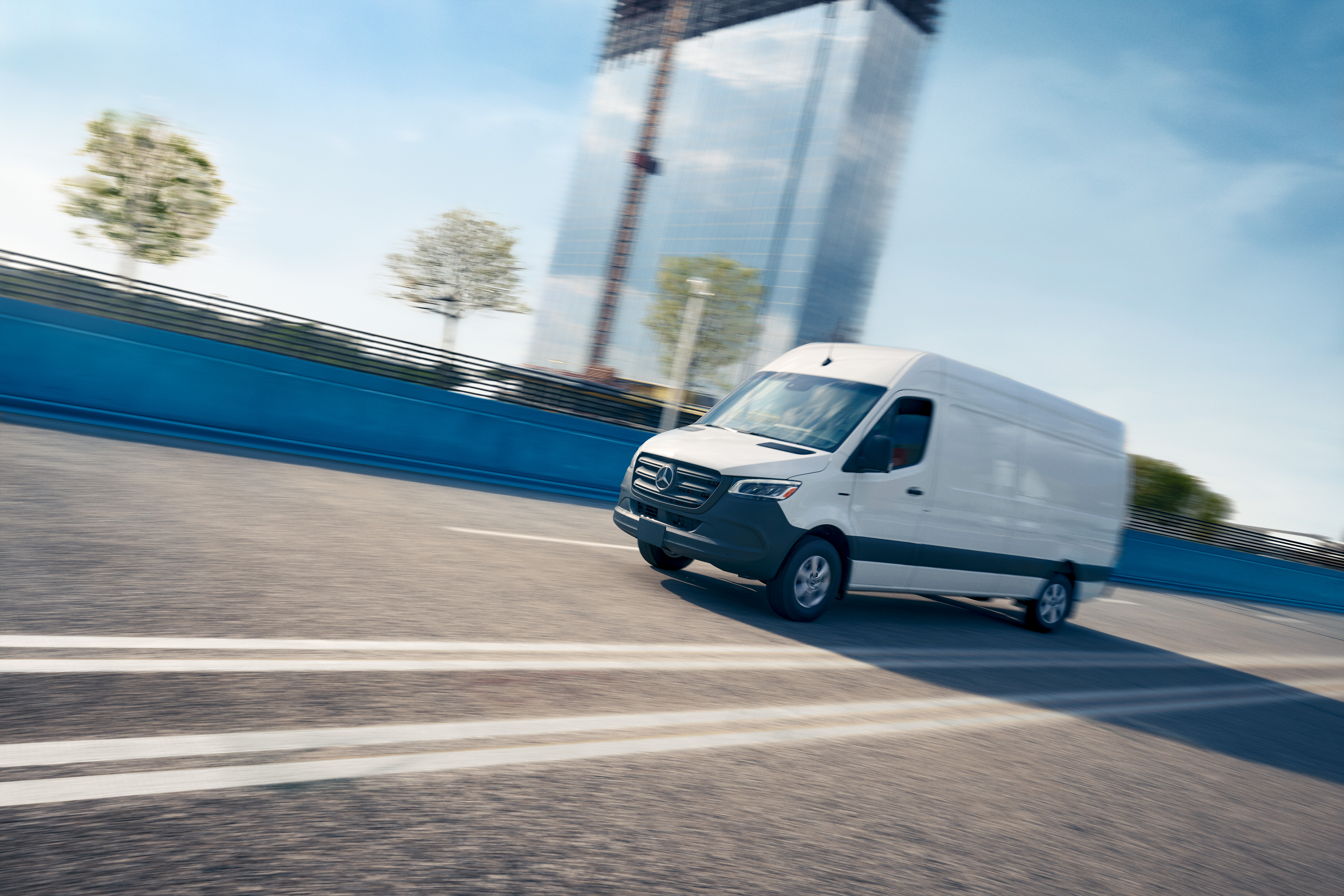 Onboard Service App | Mercedes-Benz Transporter. Ein weißer Lieferwagen fährt auf einer Straße und wirbt für die Mercedes-Benz Service-App mit Online-Terminbuchung.