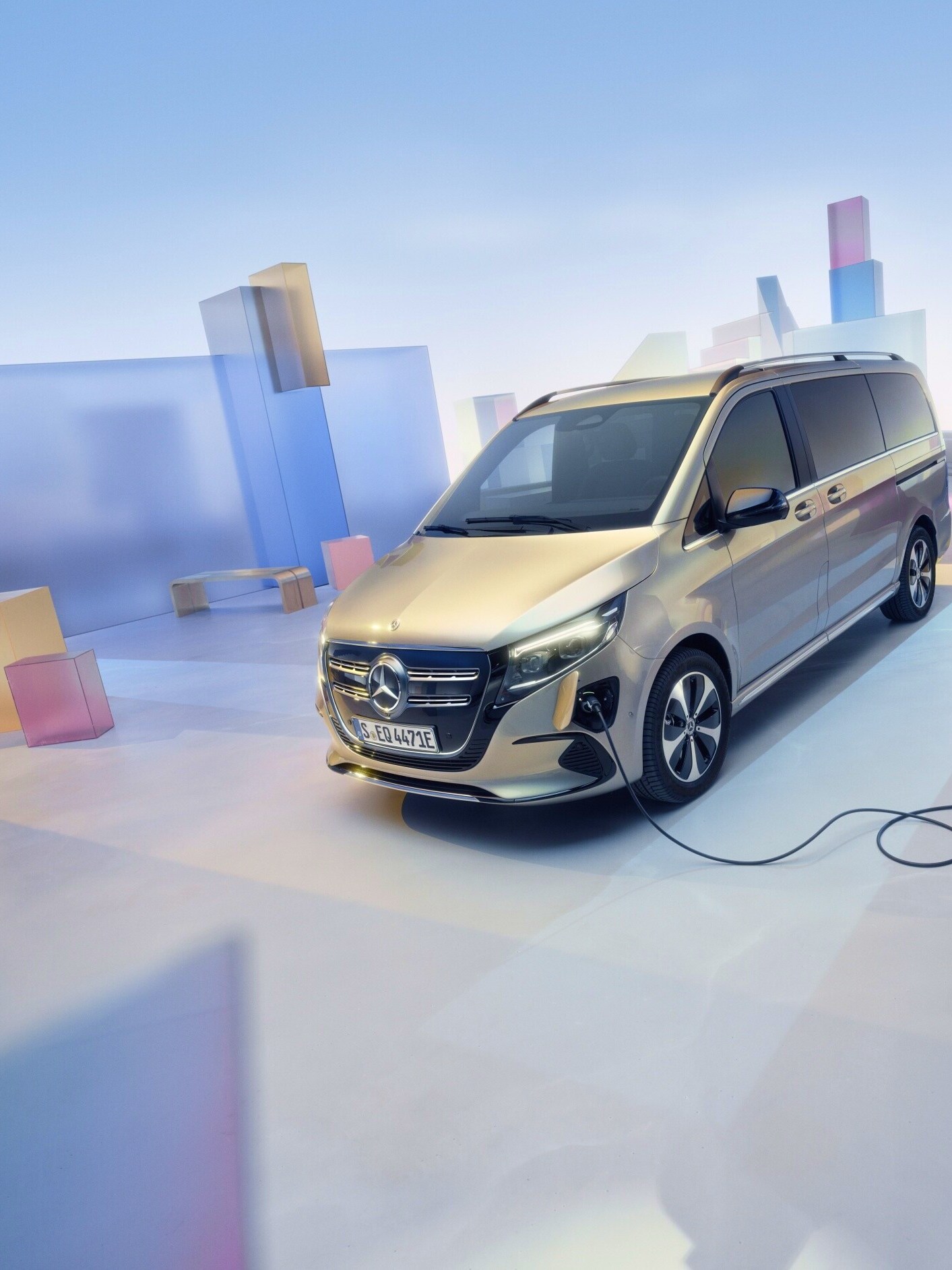 Der goldener Mercedes-Benz EQV in einer grafischen Landstadt an einer Ladestation.