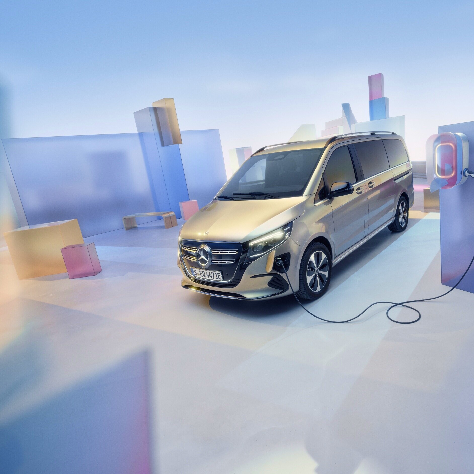 Transporter mit Elektroantrieb | Mercedes-Benz Der goldener Mercedes-Benz EQV in einer grafischen Landstadt an einer Ladestation.