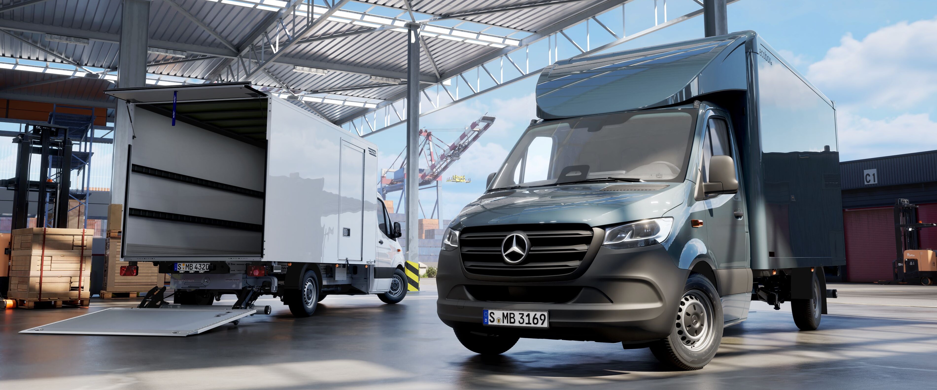 Ein Transporter mit Aufbau steht in einer Halle neben einem Transporter mit offenem Laderaum.